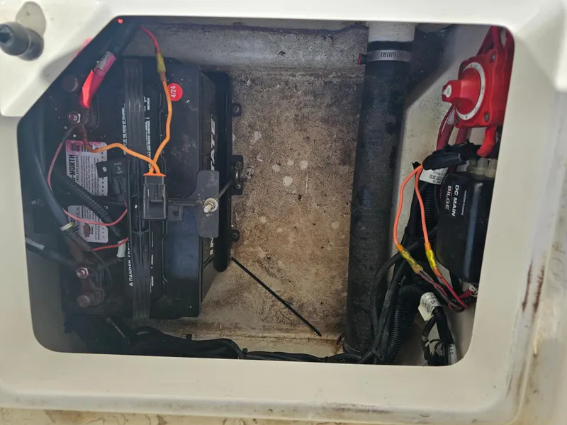 Slide: The Image of Battery compartment of a 2012 Boston Whaler 210 Montauk boat, showing wiring and connections. - 33