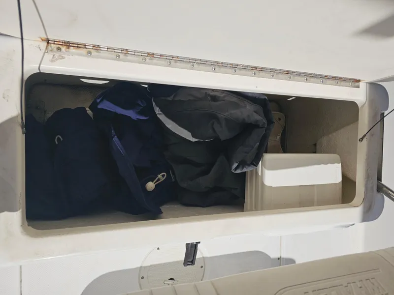 Slide: The Image of Storage compartment on a 2012 Boston Whaler 210 Montauk boat, containing gear and equipment. - 37