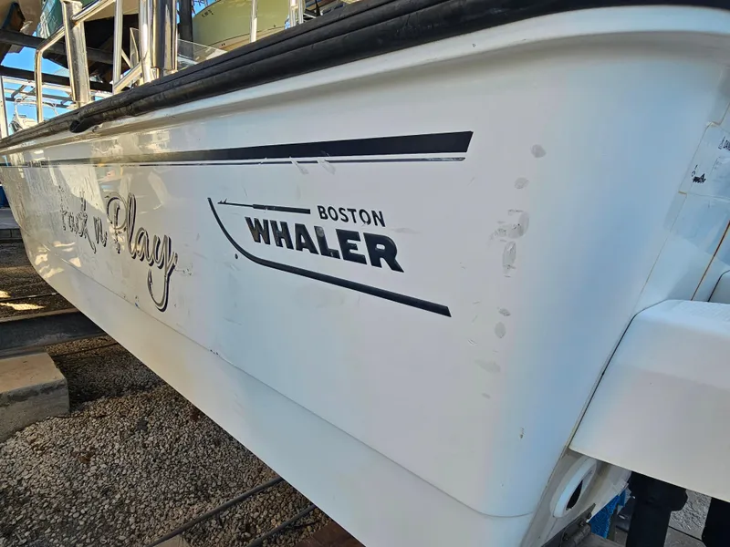 Slide: The Image of 2012 Boston Whaler 210 Montauk boat side view with logo and text. - 4