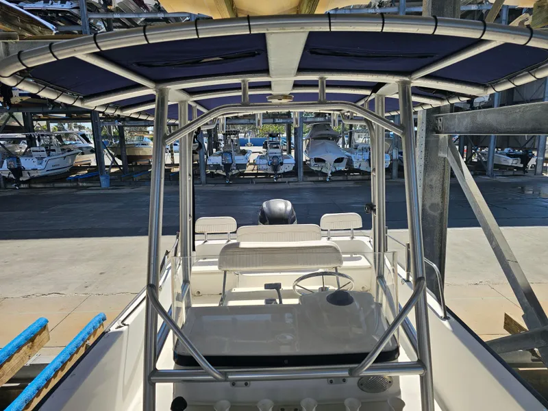 Slide: The Image of 2012 Boston Whaler 210 Montauk boat interior with steering wheel and seating, in storage facility. - 43