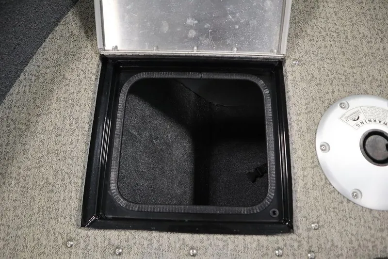 Slide: The Image of 2023 Tracker V16 Pro Guide WT storage compartment with open hatch on carpeted floor. - 15