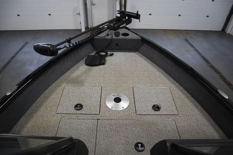 Slide: The Image of 2023 Tracker V16 Pro Guide WT boat interior with storage compartments and trolling motor. - 16