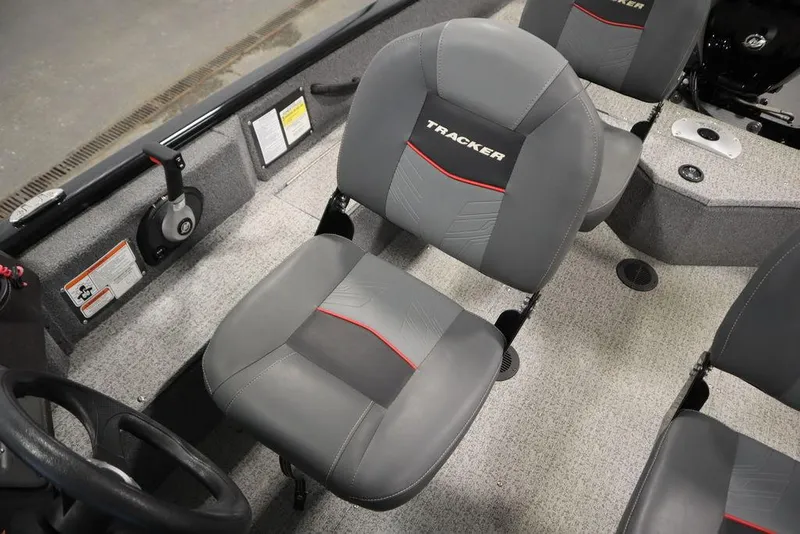 Slide: The Image of 2023 Tracker V16 Pro Guide WT boat interior with gray seating and steering wheel. - 29