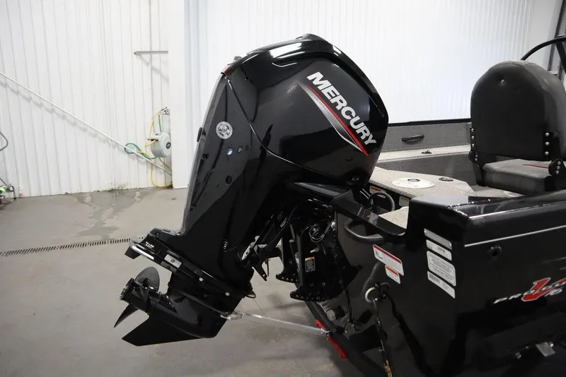 Slide: The Image of 2023 Tracker V16 Pro Guide WT with Mercury outboard motor in a garage setting. - 48