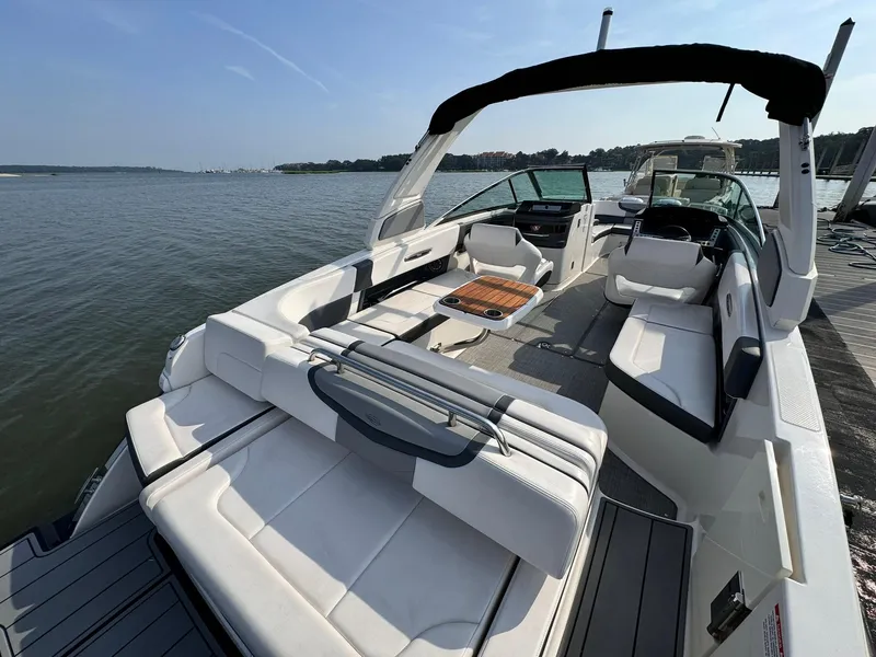 Slide: The Image of 2021 Chaparral 307 SSX boat with spacious seating and sleek design on a calm lake. - 10