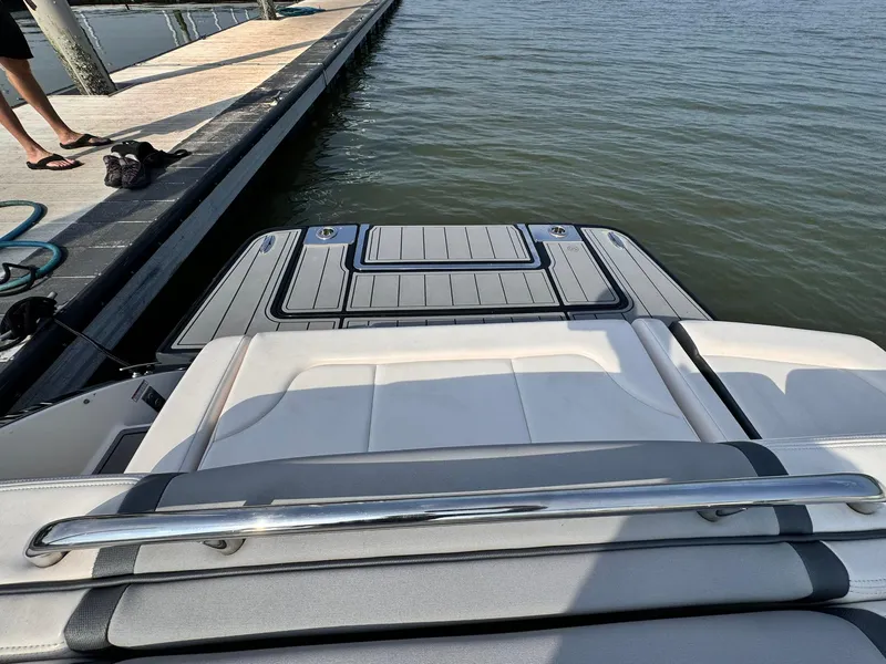 Slide: The Image of 2021 Chaparral 307 SSX boat at dock, featuring sleek swim platform and cushioned seating. - 11