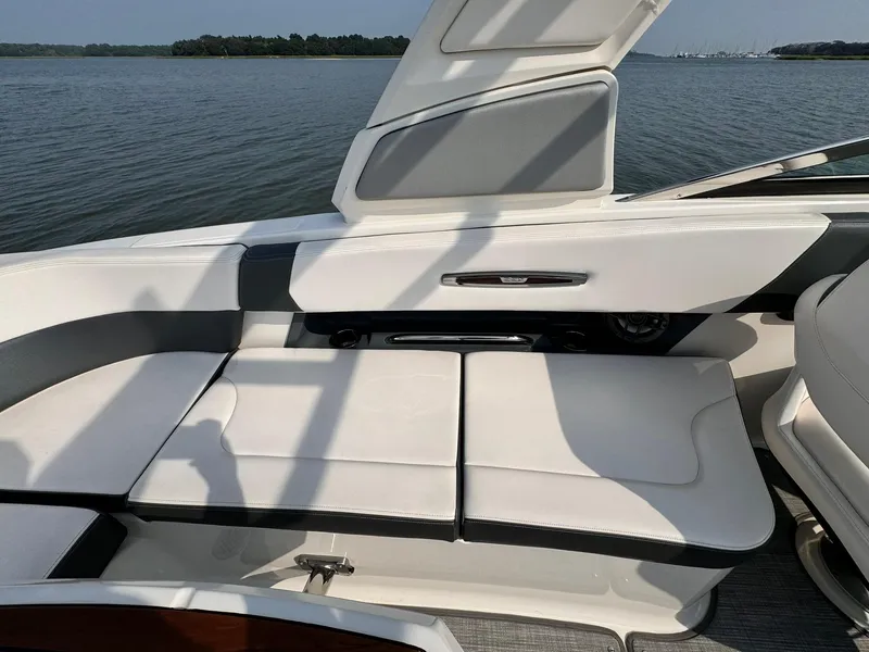 Slide: The Image of 2021 Chaparral 307 SSX boat interior with white seating, open hatch, and scenic water view. - 30