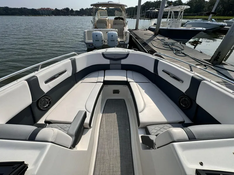 Slide: The Image of 2021 Chaparral 307 SSX boat interior with spacious seating, docked by a serene lake. - 32