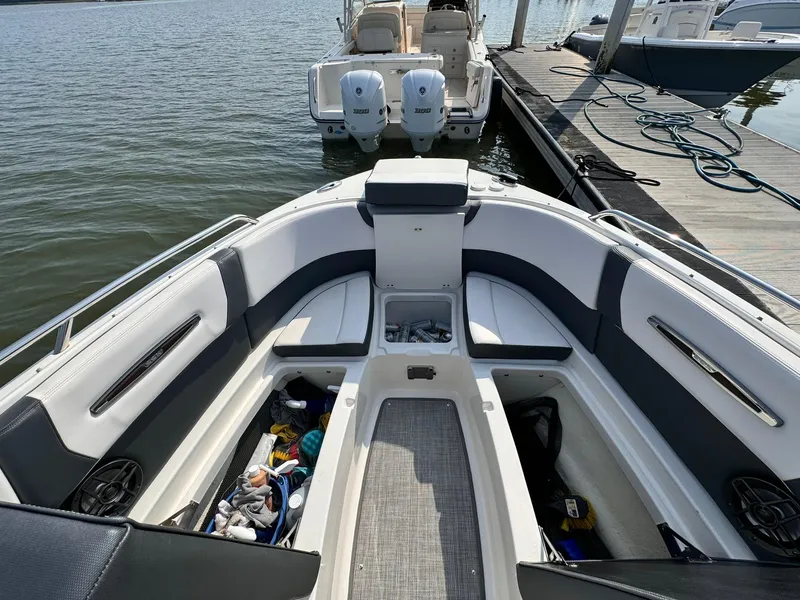 Slide: The Image of 2021 Chaparral 307 SSX boat interior with seating and storage, docked by the water. - 33