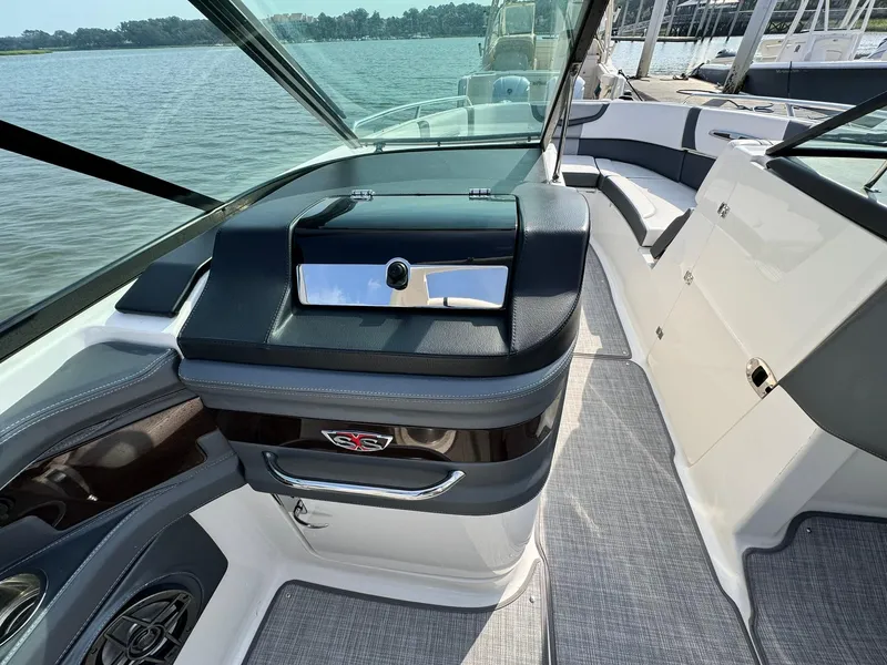 Slide: The Image of 2021 Chaparral 307 SSX boat interior with sleek dashboard and seating, docked by the water. - 34