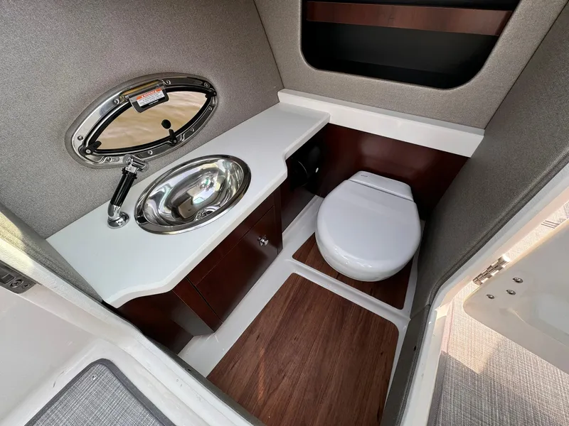 Slide: The Image of 2021 Chaparral 307 SSX boat bathroom with sink, toilet, and wood accents. - 36