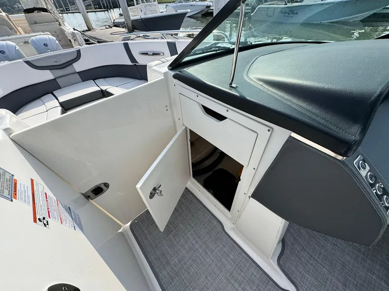 Slide: The Image of 2021 Chaparral 307 SSX boat interior with open storage compartment and seating area. - 37