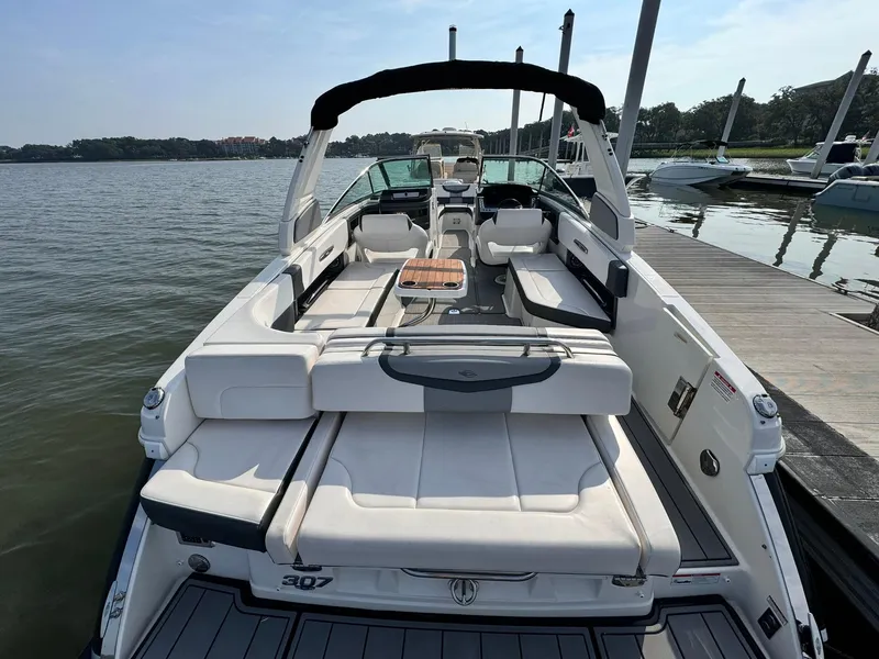 Slide: The Image of 2021 Chaparral 307 SSX boat docked, featuring spacious seating and sleek design. - 7