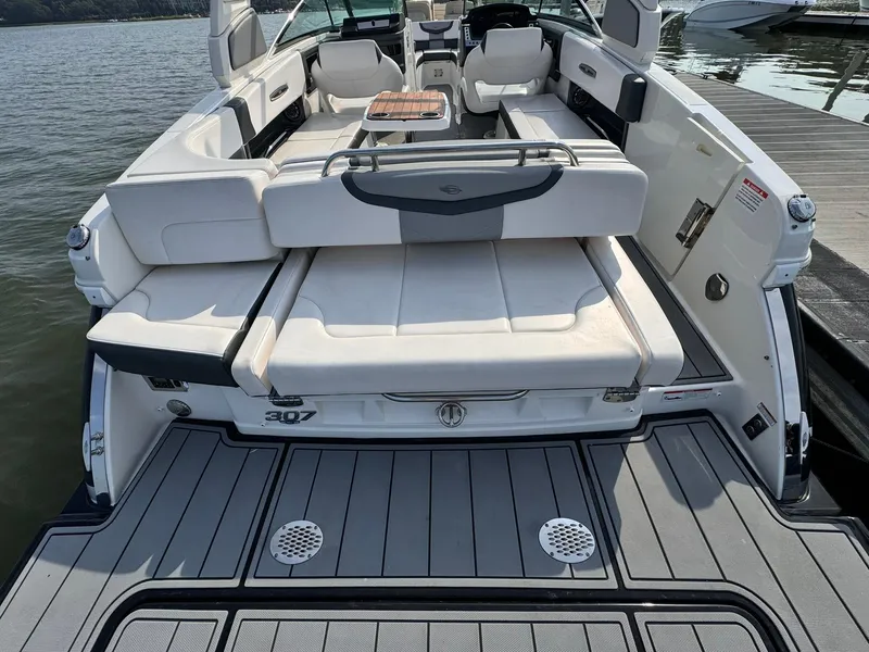 Slide: The Image of 2021 Chaparral 307 SSX boat with spacious seating and sleek design at a dock. - 8
