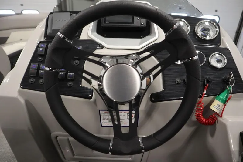 Slide: The Image of Steering wheel of 2021 SunChaser 23 SBX Eclipse Tri-Toon boat, featuring modern dashboard controls. - 22
