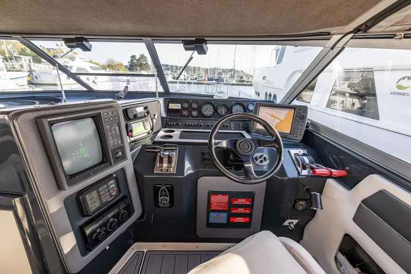 Slide: The Image of Cockpit of 1991 Sea Ray 420 Sundancer with navigation equipment and steering wheel. - 15