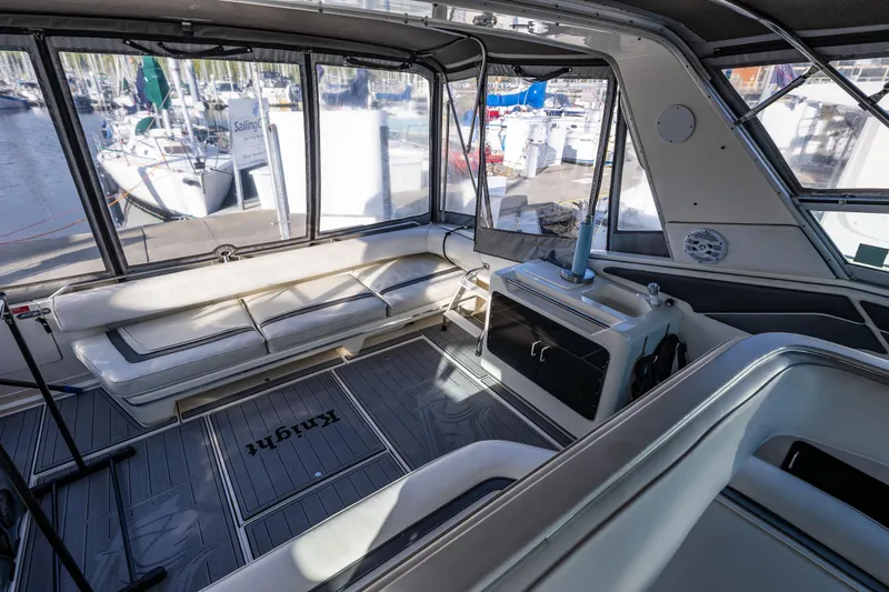 Slide: The Image of 1991 Sea Ray 420 Sundancer interior with seating and marina view. - 16