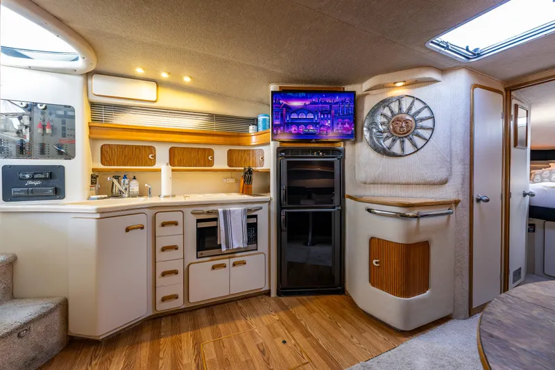 Slide: The Image of Interior of 1991 Sea Ray 420 Sundancer yacht with modern kitchen and entertainment area. - 19