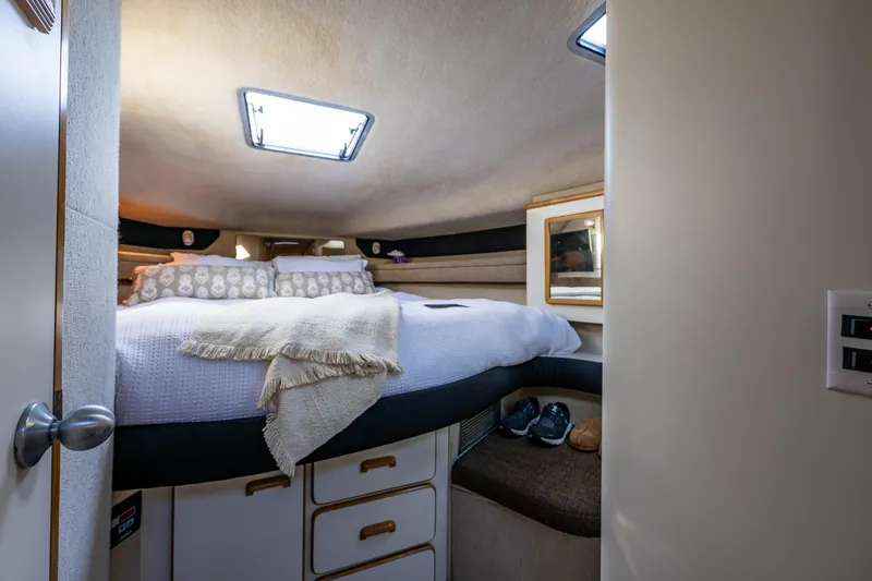 Slide: The Image of Cozy bedroom interior of 1991 Sea Ray 420 Sundancer yacht with skylight and storage. - 24