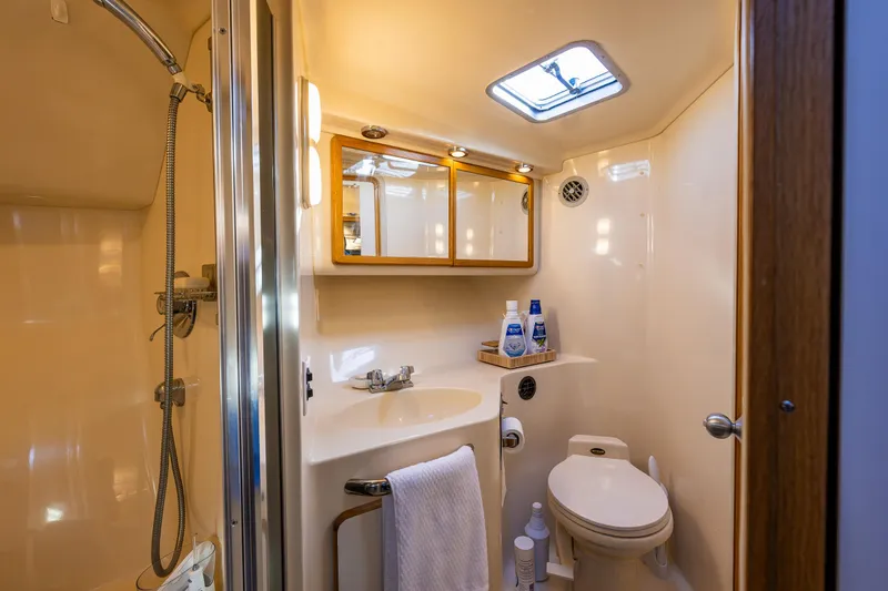 Slide: The Image of Bathroom interior of 1991 Sea Ray 420 Sundancer yacht, featuring shower, sink, and toilet. - 29