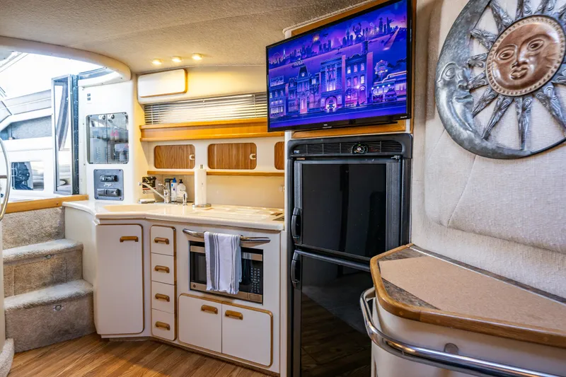 Slide: The Image of Interior of 1991 Sea Ray 420 Sundancer yacht with modern kitchen and TV. - 31