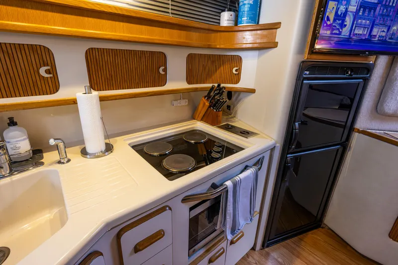 Slide: The Image of Kitchen area of a 1991 Sea Ray 420 Sundancer yacht with stove and fridge. - 32