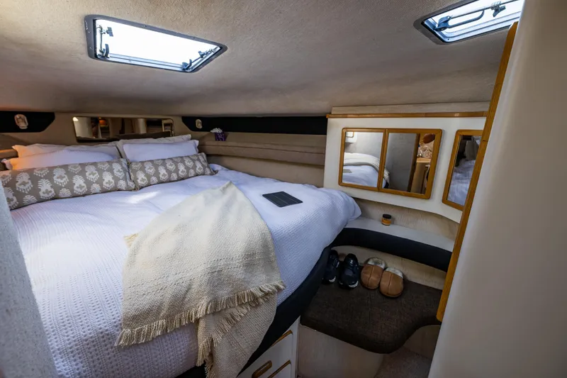 Slide: The Image of Cozy bedroom interior of 1991 Sea Ray 420 Sundancer yacht with plush bedding and mirrors. - 34