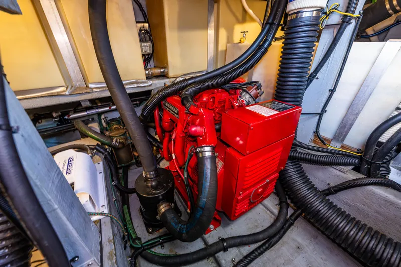 Slide: The Image of Engine room of 1991 Sea Ray 420 Sundancer with red machinery and black hoses. - 39