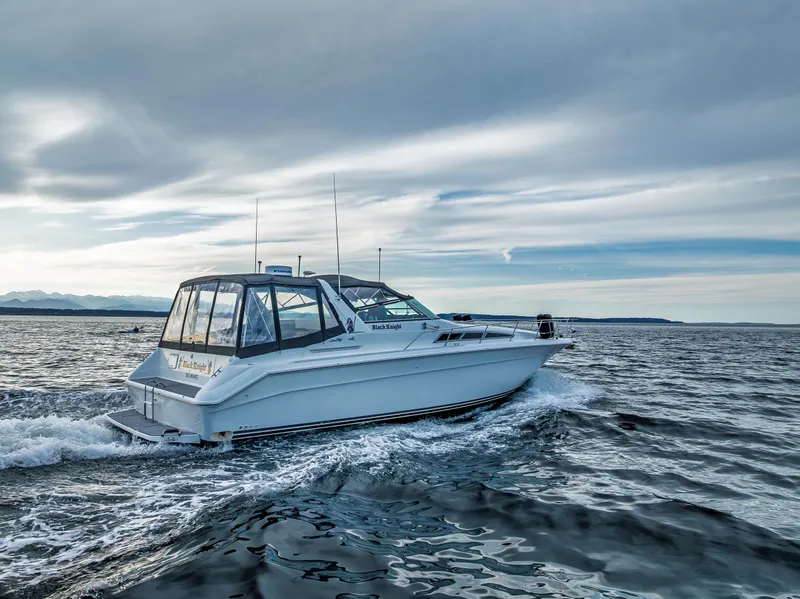 Slide: The Image of 1991 Sea Ray 420 Sundancer cruising on open water under a cloudy sky. - 5