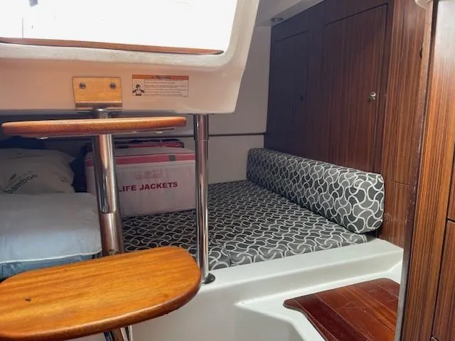Slide: The Image of 2016 Pursuit OS 325 Offshore cabin interior with wooden steps, patterned seating, and life jackets. - 9