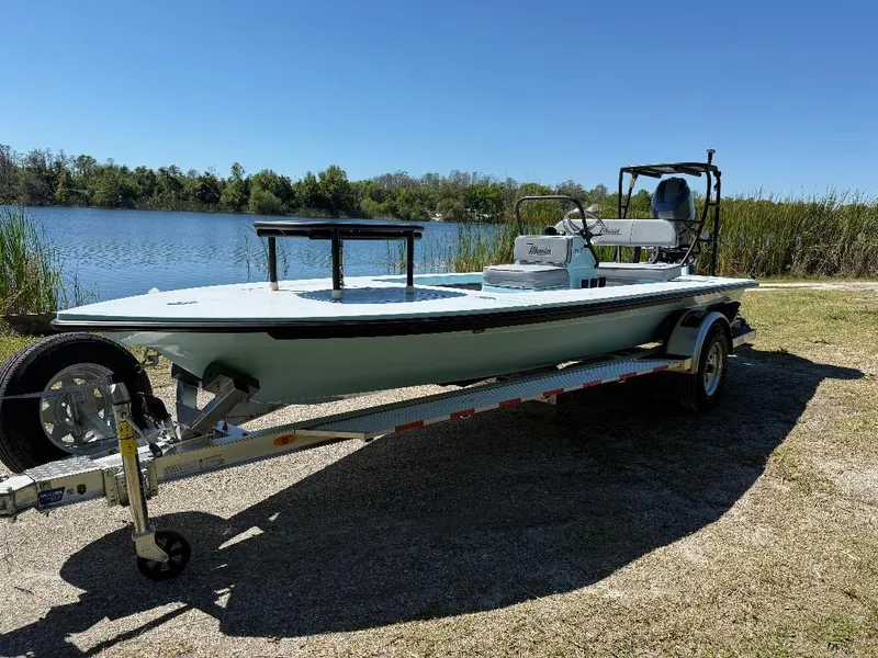 Slide: The Image of 2025 Maverick HPX 17 HPX-S boat on trailer by a lake under clear blue sky. - 11