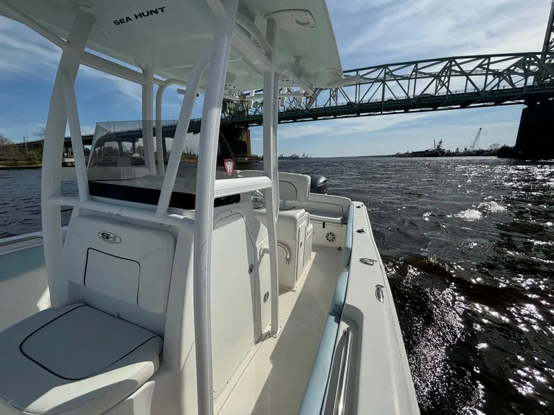 Slide: The Image of 2014 Sea Hunt Ultra 234 boat cruising under a bridge on a sunny day. - 16