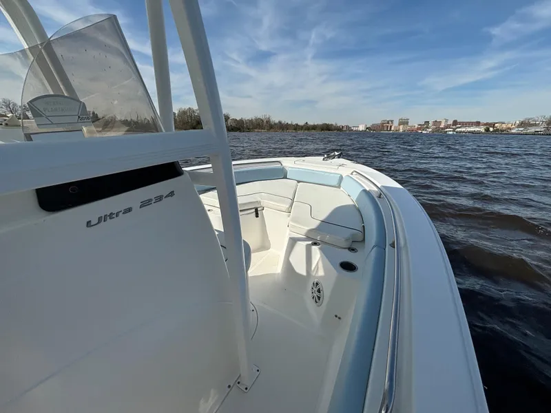 Slide: The Image of 2014 Sea Hunt Ultra 234 boat on calm water under a clear blue sky. - 18