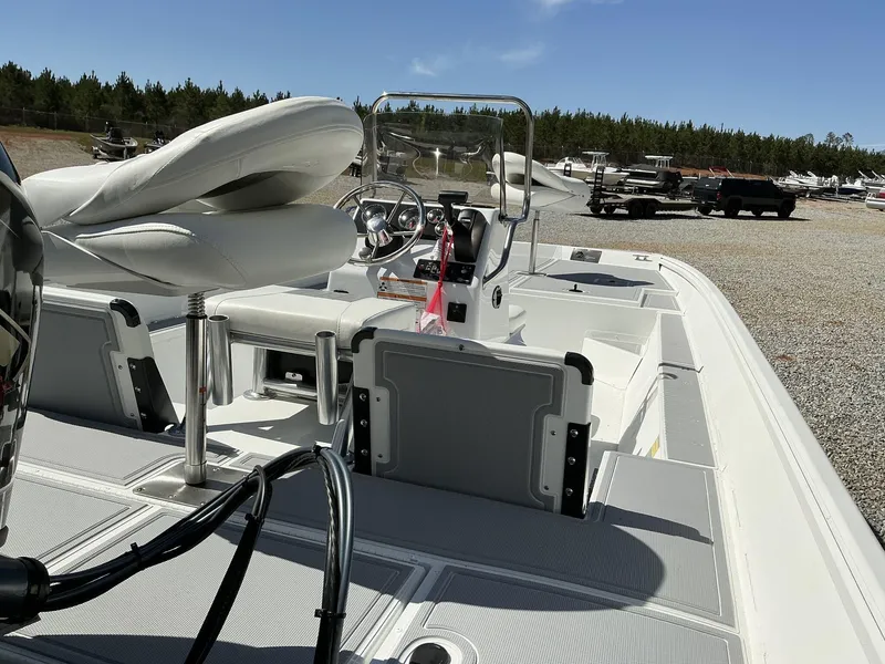 Slide: The Image of 2025 G3 Bay 20 boat interior with steering console and seating, parked outdoors. - 15