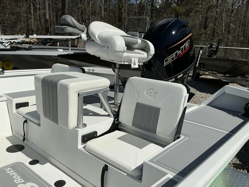 Slide: The Image of 2025 G3 Bay 20 boat interior with seating and motor, in a wooded outdoor setting. - 9
