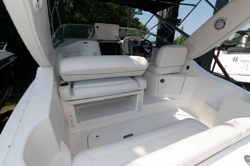 Slide: The Image of 2008 Bayliner 285 boat interior with white seating and steering area. - 10