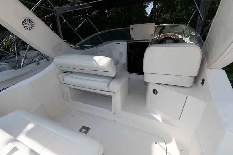 Slide: The Image of 2008 Bayliner 285 boat interior with white seating and steering area. - 13