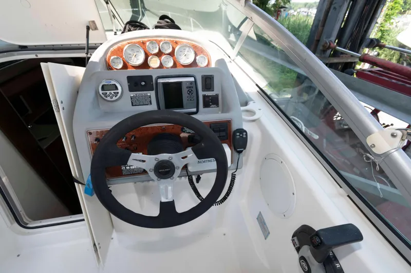Slide: The Image of 2008 Bayliner 285 boat dashboard with steering wheel and control panel. - 16