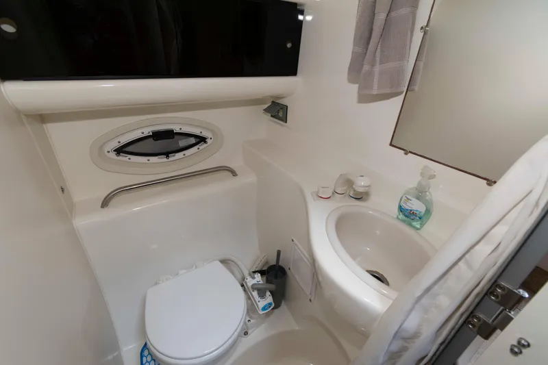 Slide: The Image of Compact bathroom in 2008 Bayliner 285 boat with toilet, sink, and porthole window. - 17