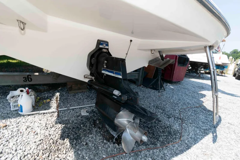 Slide: The Image of 2008 Bayliner 285 boat stern with outboard motor on gravel surface. - 19