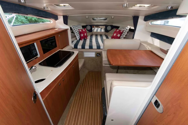 Slide: The Image of 2008 Bayliner 285 interior with kitchenette, dining area, and cozy sleeping space. - 4