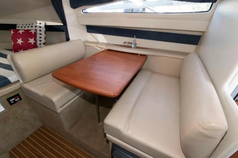 Slide: The Image of Interior of 2008 Bayliner 285 boat with cozy dining area and star-patterned pillows. - 7