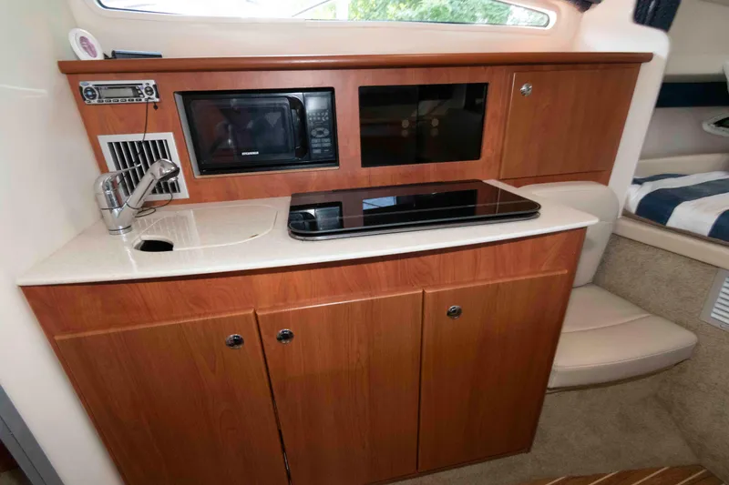 Slide: The Image of 2008 Bayliner 285 boat interior kitchen with microwave, sink, and stove. - 8