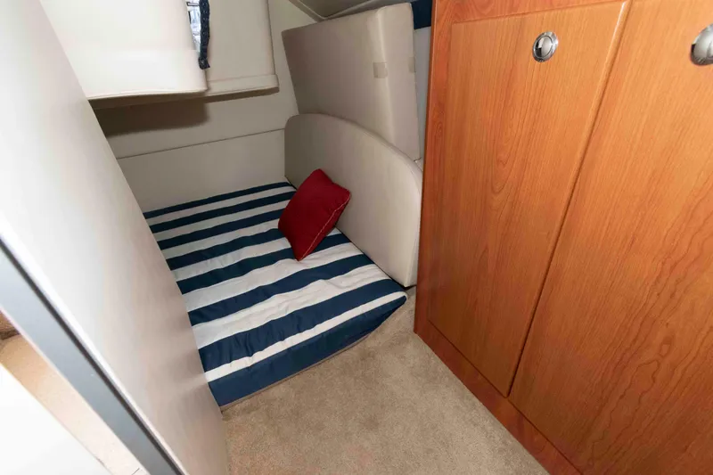 Slide: The Image of 2008 Bayliner 285 cabin interior with striped bedding and wooden cabinetry. - 9