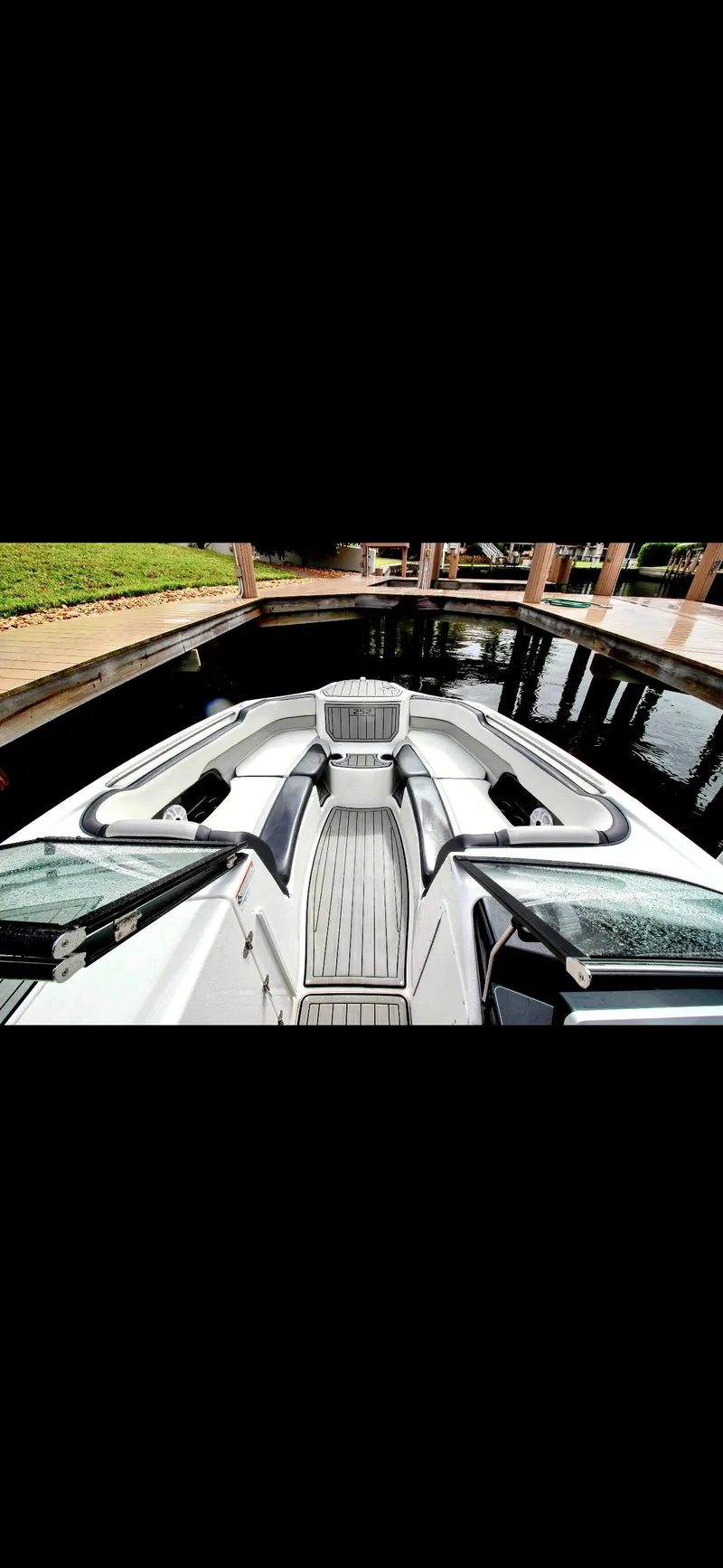 Slide: The Image of 2023 Yamaha Boats 252SD, sleek design, docked in a serene marina setting. - 11