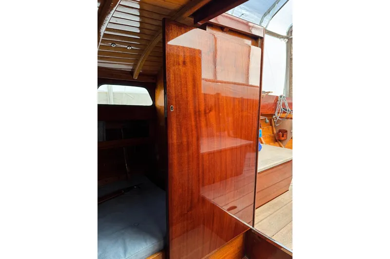 Slide: The Image of Interior view of a 1979 Nordic Folkboat, showcasing polished wooden surfaces and cabin details. - 23