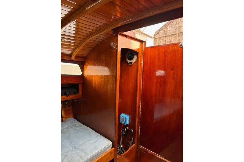 Slide: The Image of Interior of a 1979 Nordic Folkboat with polished wood paneling and seating. - 24
