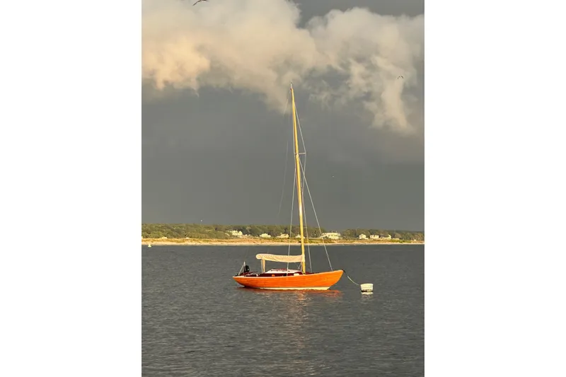 Slide: The Image of Vintage 1979 Nordic Folkboat sailing on calm waters under dramatic sky. - 26