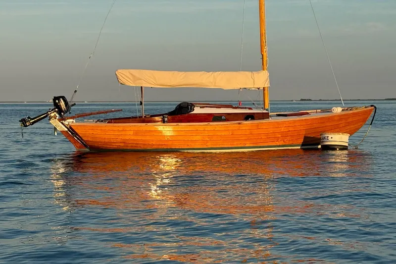Slide: The Image of Vintage 1979 Nordic Folkboat with wooden hull, anchored on calm water at sunset. - 6