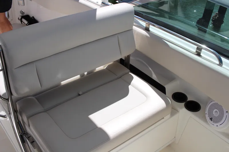 Slide: The Image of 2014 Boston Whaler 270 Vantage boat interior with cushioned seating and cup holders. - 12